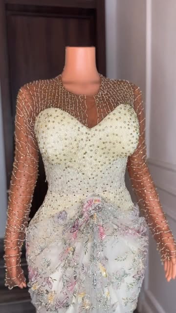 Ivory beaded gown with sheer sleeves on a mannequin